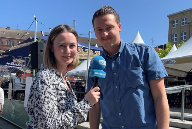 Die RN-Reporter Julia Segantini und Tim Hübbertz schauen auf dem Hansaplatz Dortmund in die Kamera.