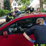 Kräfte der Hauptfeuer- und Rettungswache stehen an einem Auto, in dem ein vierjähriges Mädchen eingeschlossen ist.