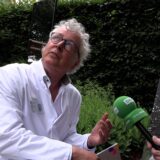 Chefarzt Prof. Dr. Boris Zernikow sitzt im Garten neben einem besonderen Spiegel, der beeinträchtigten Kindern den Blick in den Himmel ermöglicht