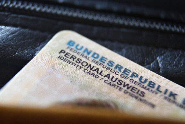 Ein deutscher Personalausweis ragt aus einer Geldbörse heraus.