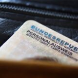 Ein deutscher Personalausweis ragt aus einer Geldbörse heraus.