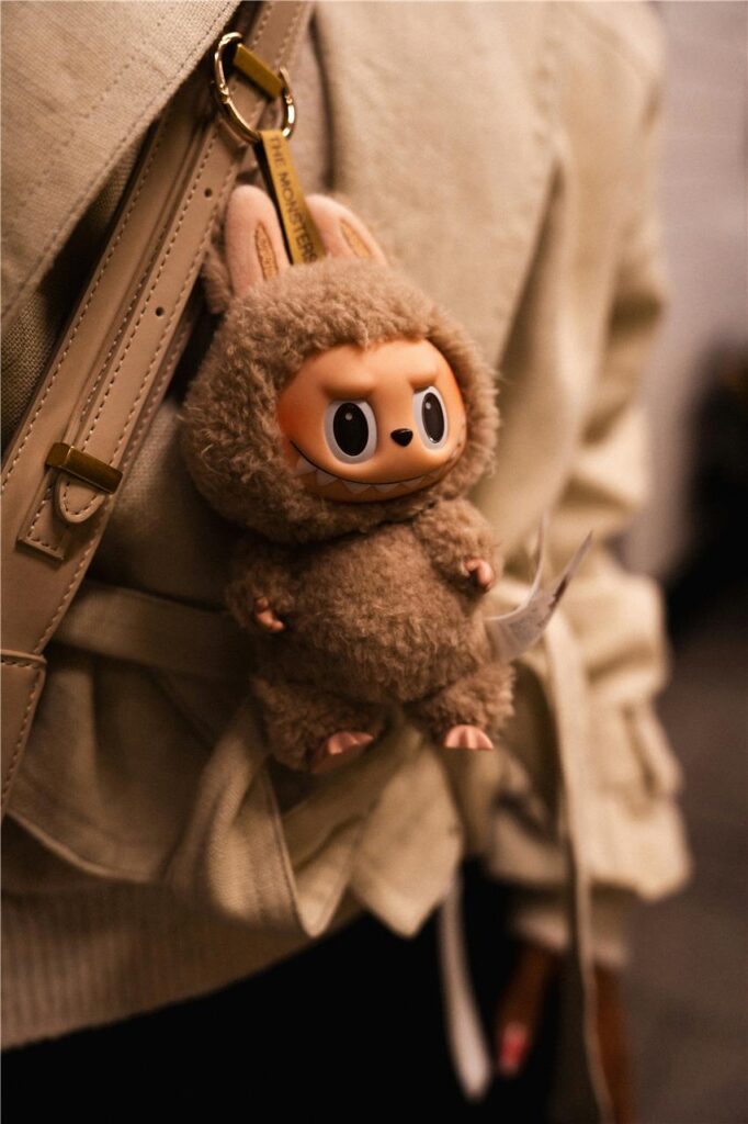 Ein Labubu hängt an der Tasche einer Frau. Ein Labubu hängt an der Tasche einer Frau.