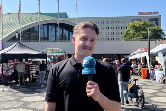 Tim Hübbertz steht auf dem Theatervorplatz in Dortmund und schaut in die Kamera.