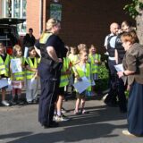 Polizei mit Kindern und einer Frau an einer Schule
