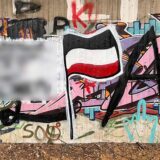 Eine Wand mit Graffiti, darunter eine Reichsflagge.