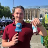 Tim Hübbertz hält ein Glas Wasser in die Kamera.