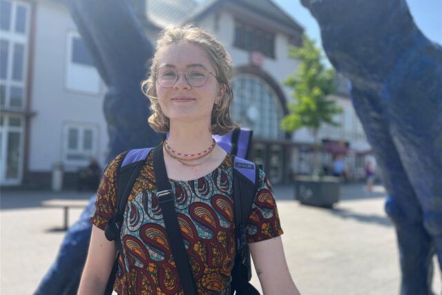 Julia May steht vor der Skulptur am Halterner Bahnhof.