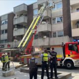 Ein Feuerwehrfahrzeug mit ausgefahrener Drehleiter vor einem Wohnhaus am Place d’Arras in Herten, davor weitere Einsatzkräfte.