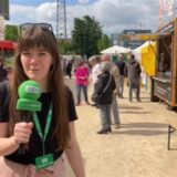 Reporterin Janka Hardenacke berichtet mit Mikrofon in der Hand vom Hafenbecken.