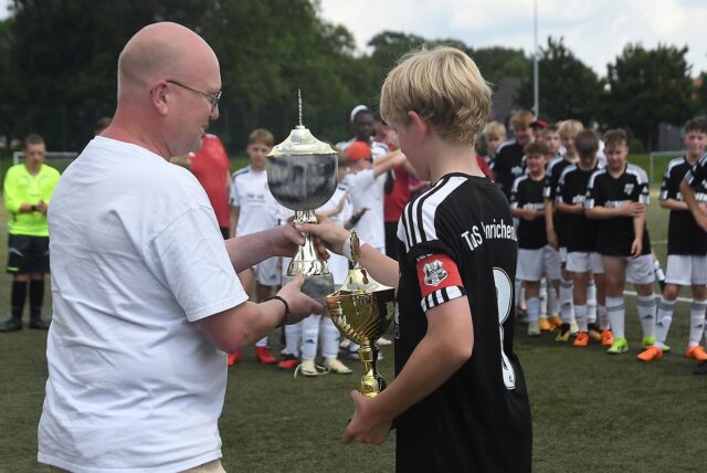 Bei den D-Junioren durfte Carsten Cwik (l.) vom Stadtsportverband dem TuS Henrichenburg im Jahr 2024 den Stadtmeisterschafts-Pokal übergeben.