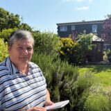 Ute Diedenhofen steht mit einem Notizblock in der Hand im Garten ihres Wohnhauses in Herten-Langenbochum.