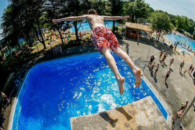 Ein Freibadbesucher springt kopfüber in ein Becken im Freibad des Revierparks Wischlingen.