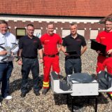Bürgermeister Andreas Stegemann, Feuerwehrchef Michael Dolega, DLRG-Einsatzleiter Sebastian Höhnerhaus, Marvin Bylitza (Sachgebietsleiter Einsatzplanung) und Pascal Sparenberg, Drohnenbeauftragter der DLRG auf dem Dach der Feuerwache Haltern.