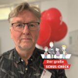 Ein Mann schaut in die Kamera. Vor das Foto ist ein Logo montiert, auf dem „Der große Schul-Check“ steht.