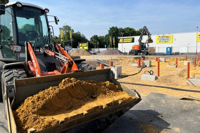Es ist ein Bagger bei Erdarbeiten zu sehen, während Fundamente für einen Neubau vorbereitet werden.