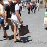 Am verkaufsoffenen Sonntag bummeln viele Menschen mit ihren Einkäufen durch die Fußgängerzone.