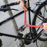 Ein Mann versucht mit einem Bolzenschneider ein Fahrradschloss aufzubrechen