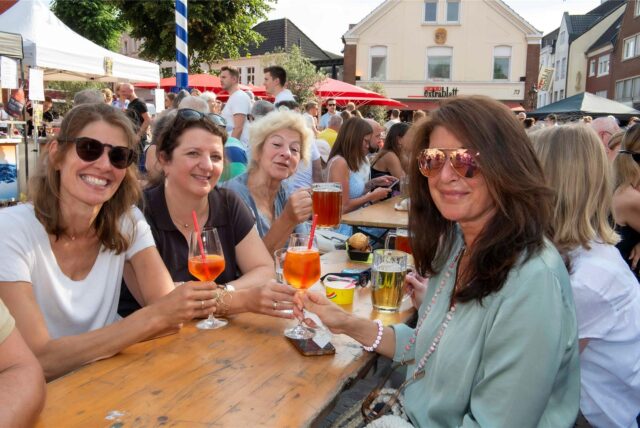 Vier Frauen sitzen an einem Tisch und trinken Aperol beim Feierabendmarkt am 18, Juni 2025 in Haltern.