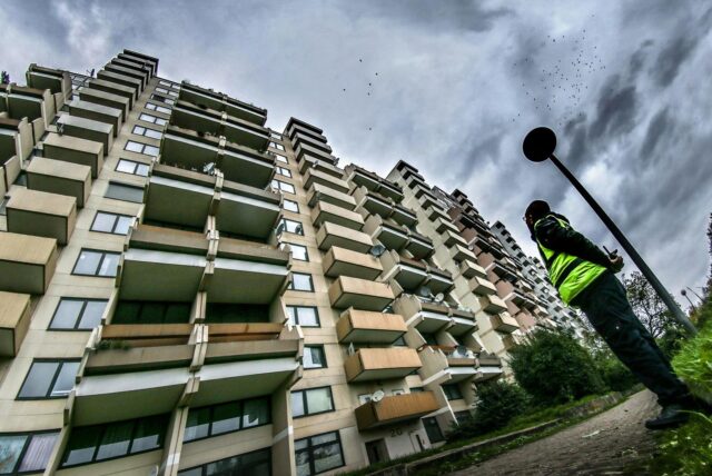 Der Hannibal-Hochhaus in Dortmund, im Vordergrund ein Sicherheitsmann, der auf das Gebäude blickt.