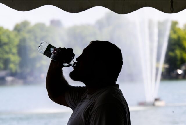 Ein Arbeiter trinkt beim Aufbau für das Maschseefest aus einer Wasserflasche.