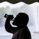 Ein Arbeiter trinkt beim Aufbau für das Maschseefest aus einer Wasserflasche.