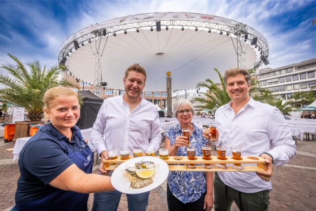 Mitarbeiter der beteiligten Gastronomien präsentieren bei Gourmedo in Dortmund Speisen und Getränke.