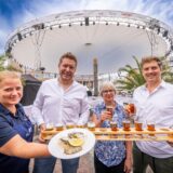 Mitarbeiter der beteiligten Gastronomien präsentieren bei Gourmedo in Dortmund Speisen und Getränke.