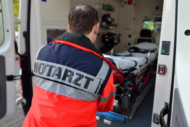 Notarzt steht vor der Tür eines Rettungswagens.