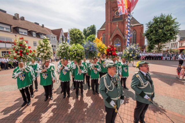 Am Sonntagmittag (22.6.2025) gab es vor der Alten Rathaus wurde für das amtierende Königspaar, als Dank für die vergangene Regentschaft einen Blumengruß, prall und farbenprächtiger Blumenschmuck in Füllhörnern jeder Kompanie. Zum Abschluss zog die große Parade vor dem Königspaar und den Gästen auf der Tribüne über den Platz.