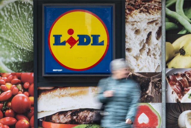 Eine Passantin geht an der Außenwerbung einer Lidl-Filiale vorbei.
