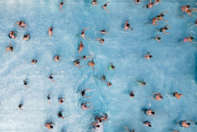 Viele Menschen in einem Schwimmbecken aus der Vogelperspektive
