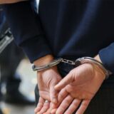 Person wird in Handschellen abgeführt.