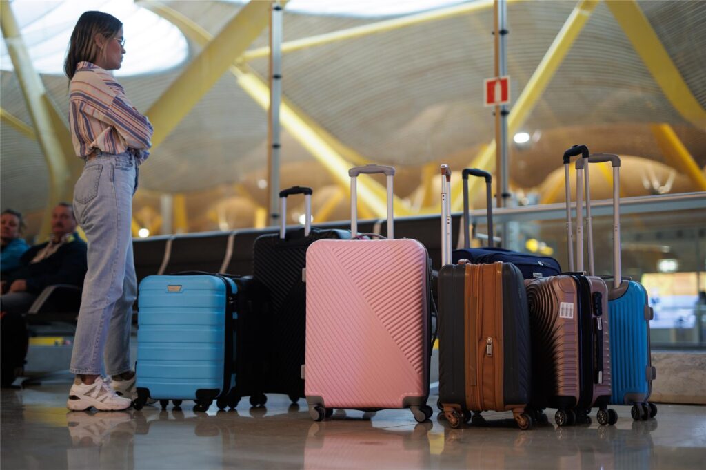 Eine Frau steht mit Koffern am Terminal T4 des Flughafens Adolfo Suarez-Madrid Barajas.