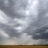 Eine Regenfront zieht über ein Getreidefeld hinweg.