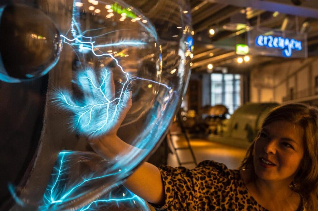 Die Frau macht im Museum „Zeitreise Strom“ in Recklinghausen ein Experiment. Die Frau macht im Museum „Zeitreise Strom“ in Recklinghausen ein Experiment.