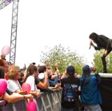 Nena steht auf der Bühne und singt ihre Fans an. Einige Fans haben pinke Luftballons.