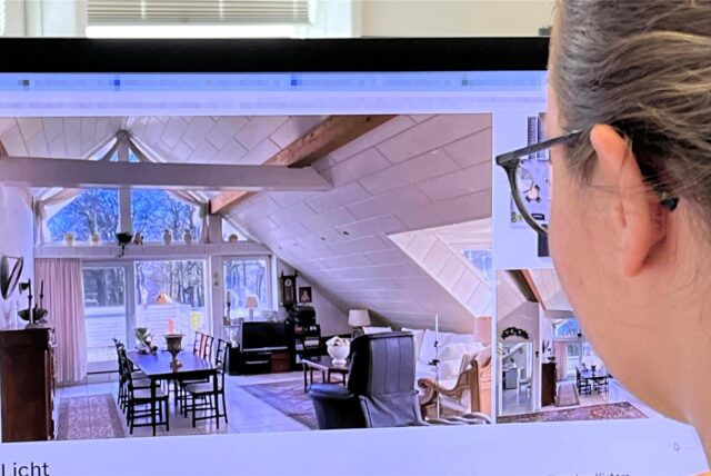 Eine junge Frau sieht sich ein Bild einer Wohnung an.