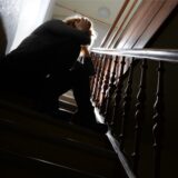 Eine Frau, die auf einer Treppe verzweifelt sitzt.
