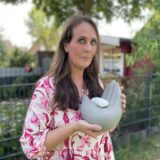 Die Dortmunderin Christina Prinz hält die Urne mit der Asche ihres verstorbenen Hundes Riku in den Händen.
