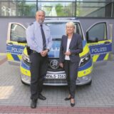 Der neue BSD-Koordinator Markus Hebel neben Polizeipräsidentin Friederike Zurhausen vor einem Polizeiauto.