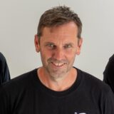 André Pawlak und Michael Volmari laufen gemeinsam über einen Fußballplatz.