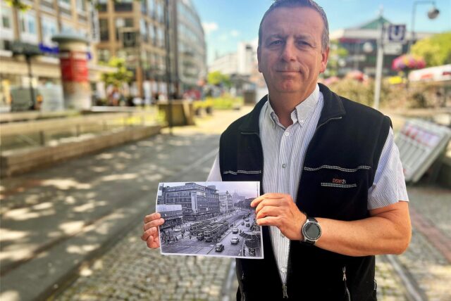 Michael Thiel zeigt ein historisches Bild von der Haltestelle Kampstraße.