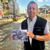 Michael Thiel zeigt ein historisches Bild von der Haltestelle Kampstraße.