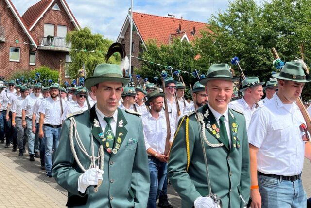 Schützen marschieren auf einen Platz.