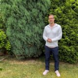 Bastian Himmeröder sitzt im Garten seines Elternhauses. Er hat ein weißes Shirt an.