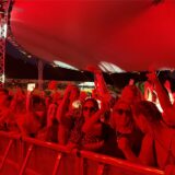 Im roten Licht feiern tausende Menschen vor der Bühne beim Sunset Beach Festival.