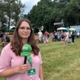 Reporterin Lara Teschers steht mit WZ-Mikrofon beim Trecker-Treck.
