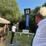 Ein Schütze legt an der Vogelstange das Gewehr an.