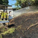 Feuerwehrleute löschen Böschungsbrand