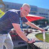 RN-Reporter Johannes Wenzel hält ein Thermometer in den Brunnen am Markt in Castrop-Rauxel.
